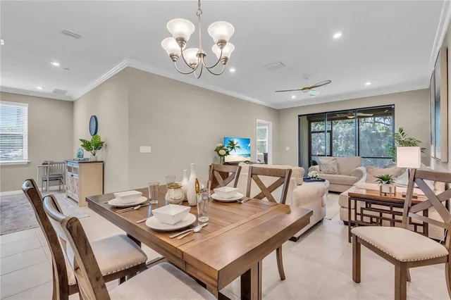 a view of a dining room with furniture a chandelier and wooden floor