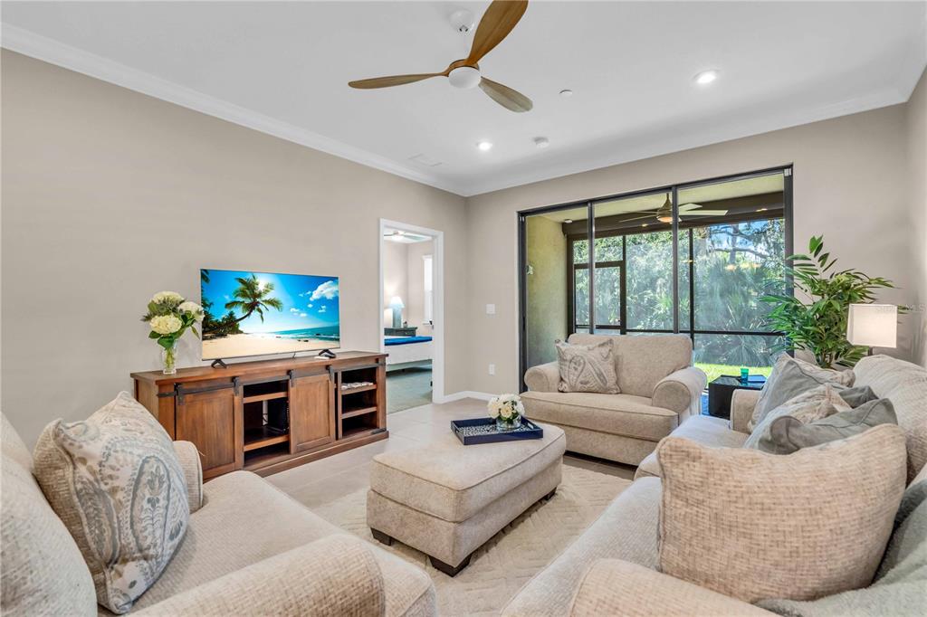 12413 Osorio Court, Unit 101 Sarasota, FL 34238 - Photo 18 of 46 a living room with furniture a large window and a fireplace