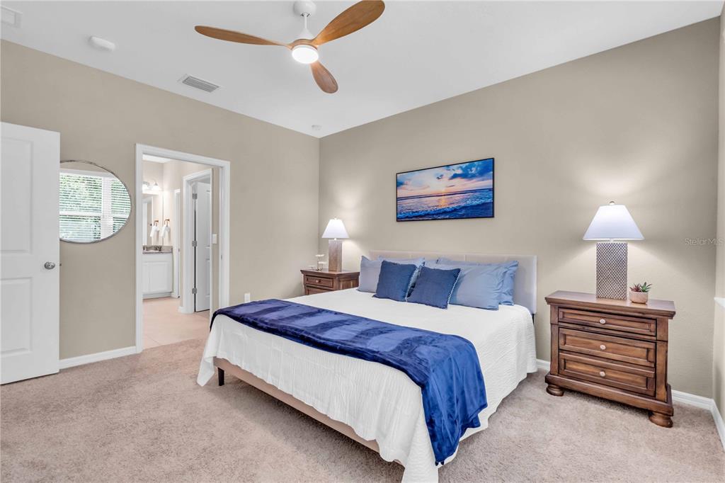 12413 Osorio Court, Unit 101 Sarasota, FL 34238 - Photo 22 of 46 a spacious bedroom with a bed and a lamp