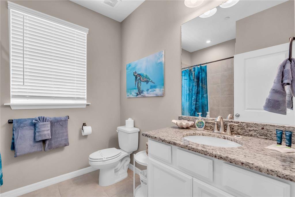 12413 Osorio Court, Unit 101 Sarasota, FL 34238 - Photo 28 of 46 a bathroom with a granite countertop sink mirror vanity and toilet
