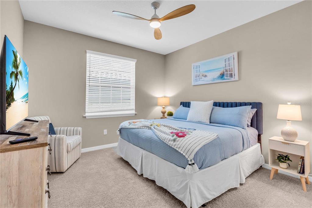 12413 Osorio Court, Unit 101 Sarasota, FL 34238 - Photo 30 of 46 a bedroom with a bed and a flat screen tv