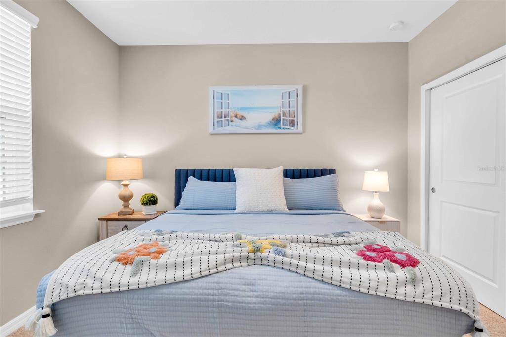 12413 Osorio Court, Unit 101 Sarasota, FL 34238 - Photo 31 of 46 a bedroom with a large bed and a lamp