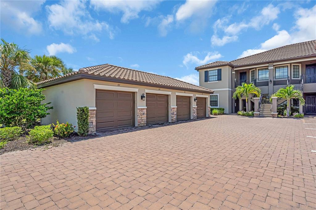 12413 Osorio Court, Unit 101 Sarasota, FL 34238 - Photo 34 of 46 a front view of house with yard and trees in the background