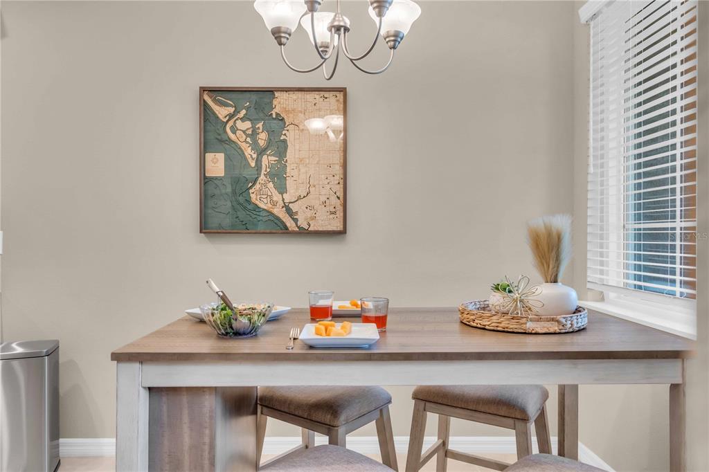 12413 Osorio Court, Unit 101 Sarasota, FL 34238 - Photo 4 of 46 a table with a vase and flowers on it