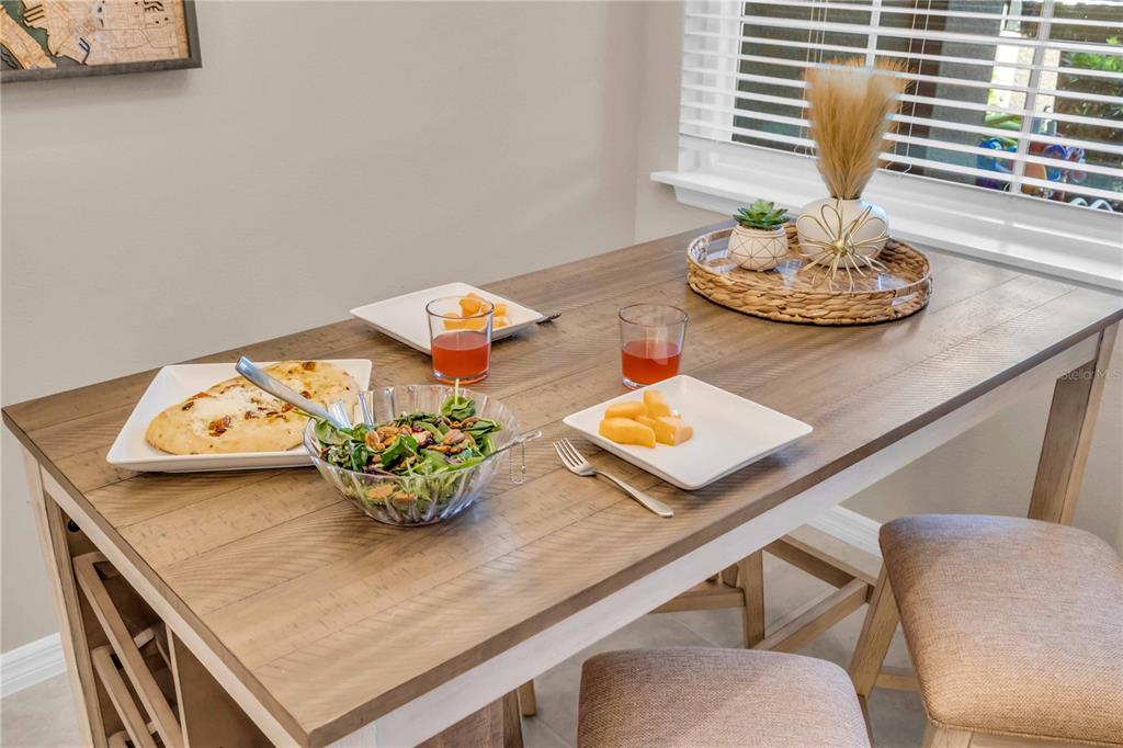 12413 Osorio Court, Unit 101 Sarasota, FL 34238 - Photo 5 of 46 a table with a dining table and a stove