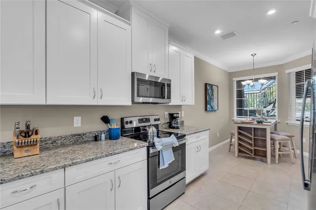 a kitchen with granite countertop white cabinets and white appliances