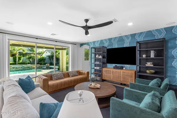 a bedroom with a large bed and a chandelier fan