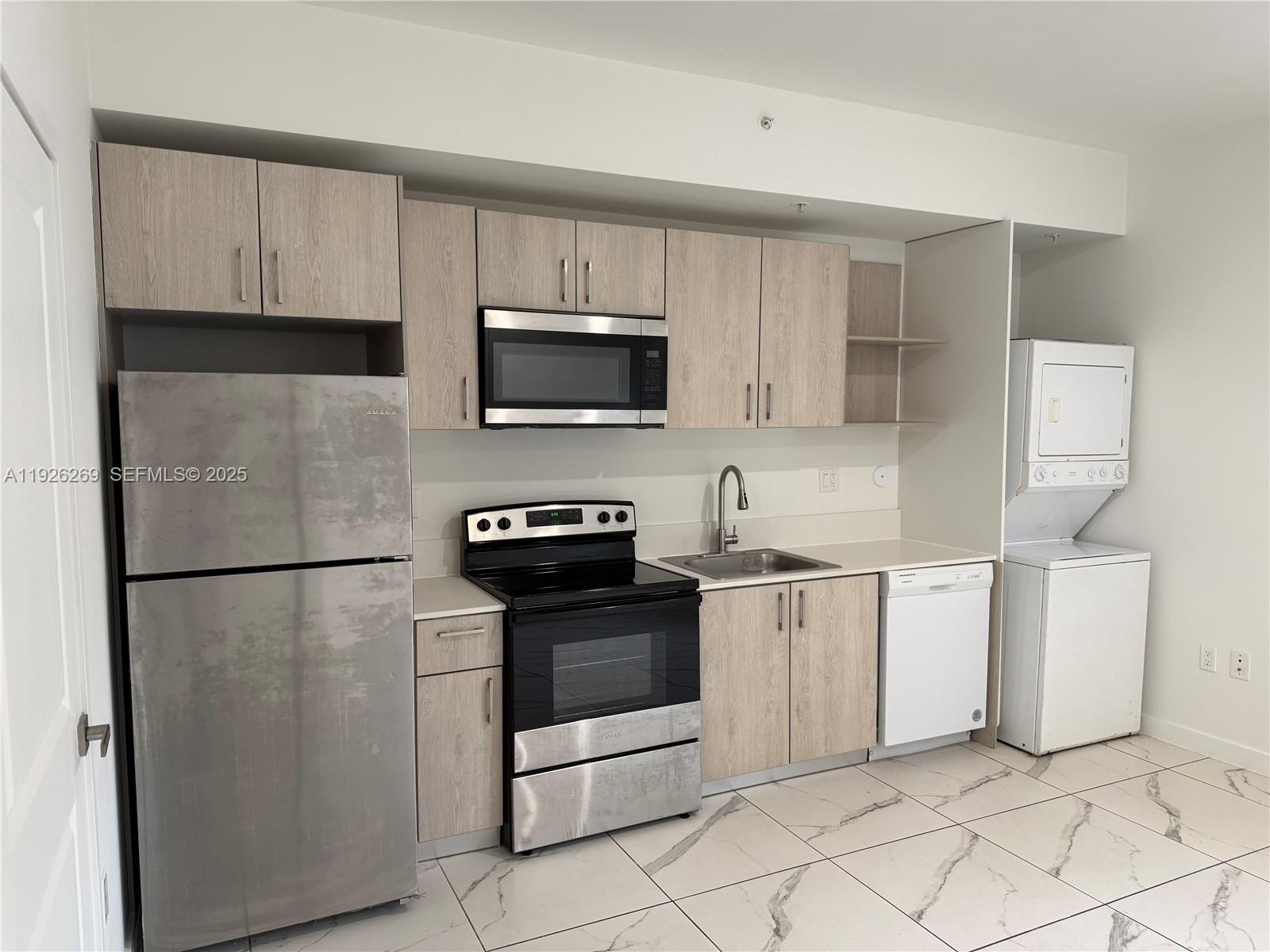 420 Southwest 7th Avenue, Unit 101 Miami, FL 33130 - Photo 5 of 16 a kitchen with stainless steel appliances granite countertop a refrigerator stove a sink and a microwave
