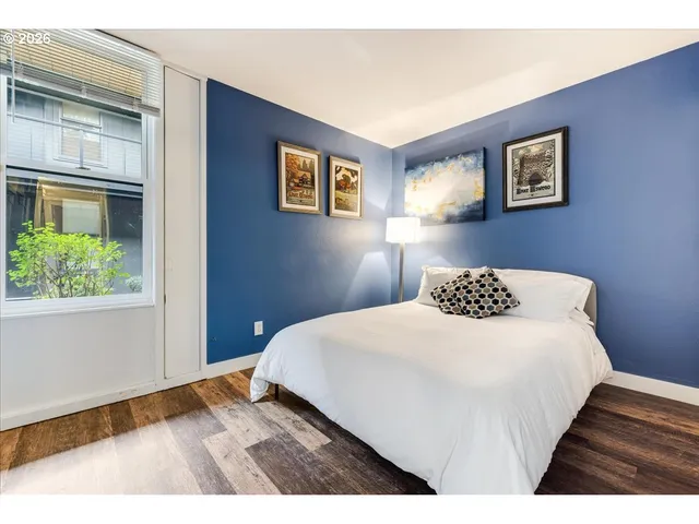 a bedroom with a bed and a painting on the wall