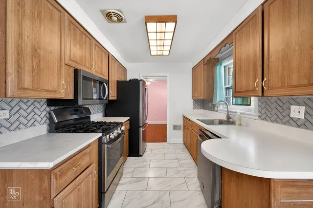a kitchen with stainless steel appliances granite countertop a sink stove and refrigerator