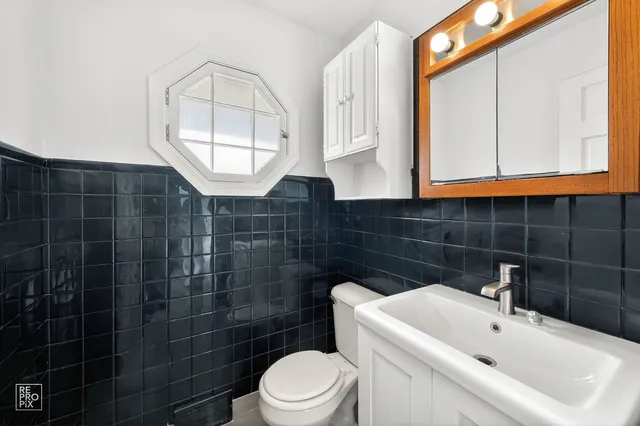 a bathroom with a sink a toilet and a mirror