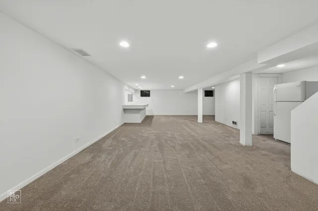 a view of a big room with refrigerator and windows