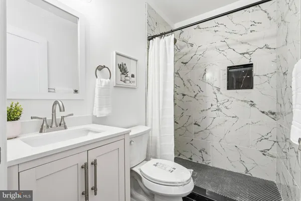 a bathroom with a sink toilet a mirror a vanity and shower