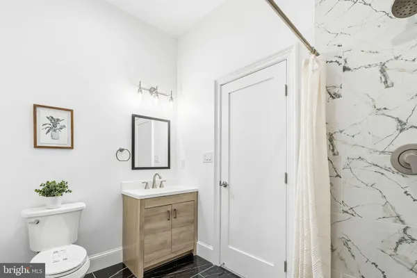 a bathroom with a sink a toilet and shower curtain