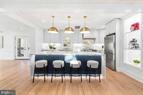a kitchen with granite countertop a table chairs and wooden floor