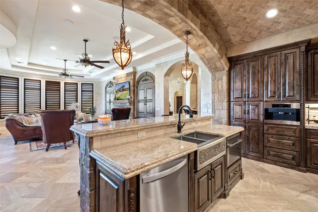 a kitchen with kitchen island granite countertop a stove and a sink