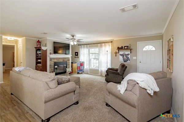 a living room with furniture a fireplace and a large window