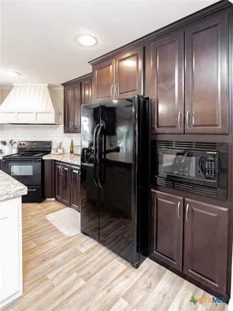 a kitchen with stainless steel appliances granite countertop a refrigerator and a stove top oven