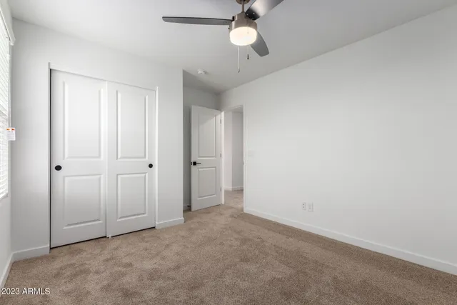 an empty room with a empty space and a ceiling fan