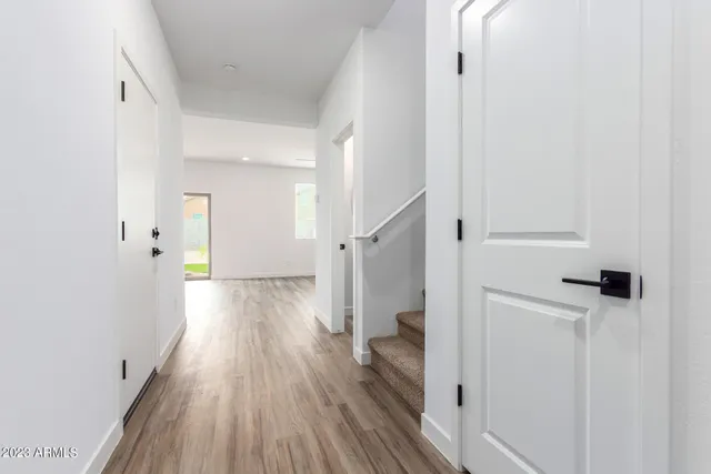 a view of a hallway with wooden floor and staircase