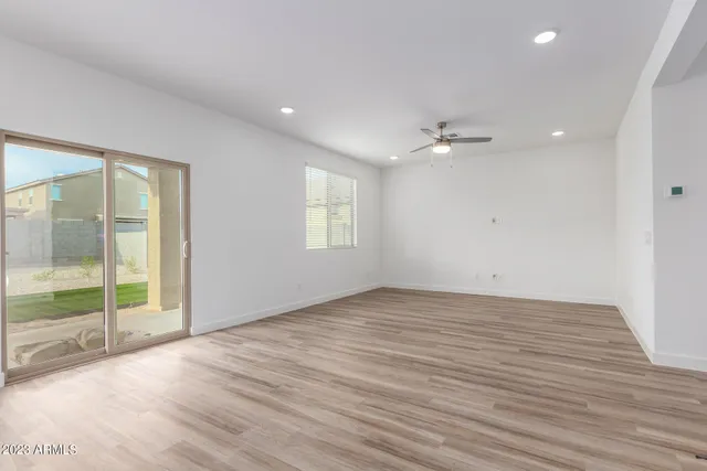 an empty room with wooden floor and a floor to ceiling window