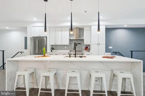 a kitchen with stainless steel appliances kitchen island granite countertop a sink and white cabinets