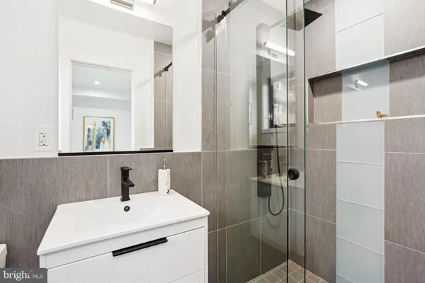 a bathroom with a sink shower and a mirror