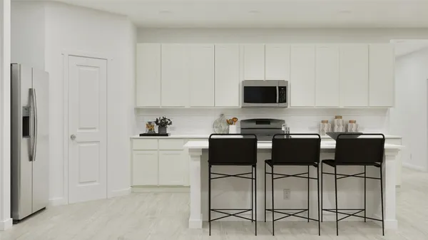 a kitchen with a stove and white cabinets