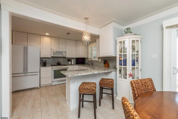 a kitchen with refrigerator a sink and chairs
