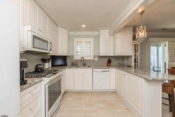 a kitchen with granite countertop a sink stainless steel appliances and cabinets