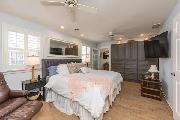 a spacious bedroom with a bed a couch and a flat screen tv