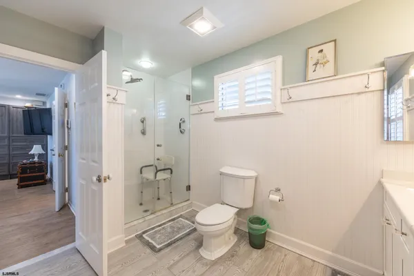 a bathroom with a granite countertop toilet a shower and a sink