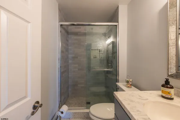 a bathroom with a granite countertop sink toilet and shower