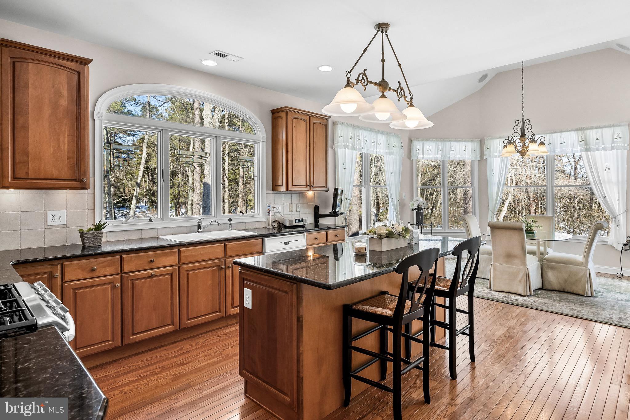 19 Big Look Trail Medford, NJ 08055 - Photo 17 of 61 a dining hall with stainless steel appliances granite countertop a stove a sink dishwasher a dining table and chairs with wooden floor
