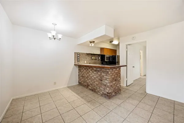 an empty room with kitchen view