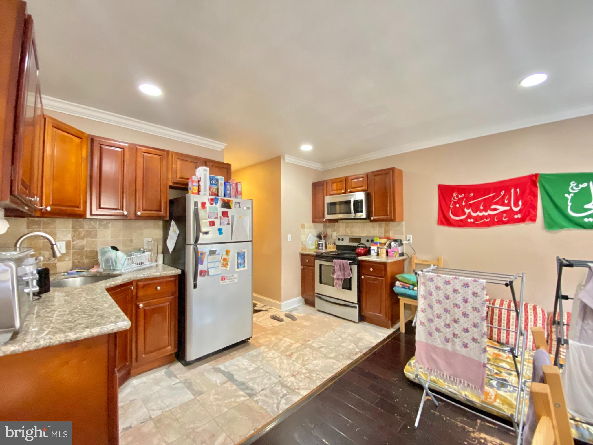 a open kitchen with stainless steel appliances granite countertop a refrigerator stove top oven and sink