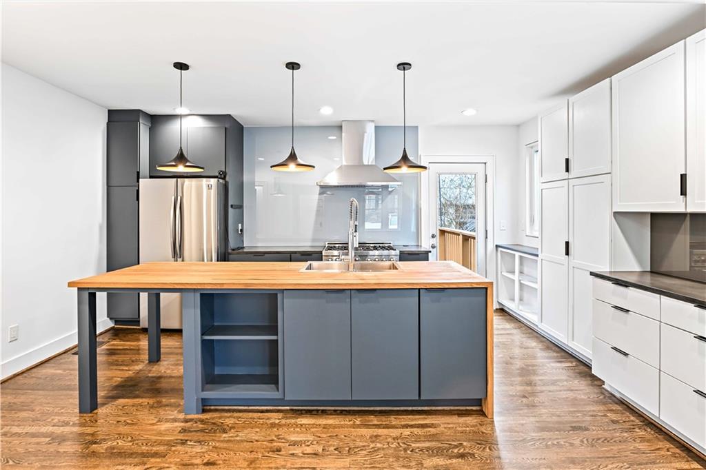 2188 Edison Avenue Northeast Atlanta, GA 30305 - Photo 13 of 51 a large kitchen with stainless steel appliances kitchen island granite countertop a table chairs and a wooden floor