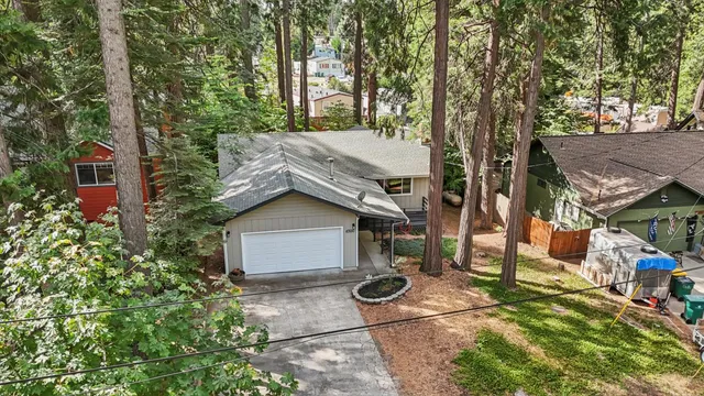 a view of a house with a yard and large tree