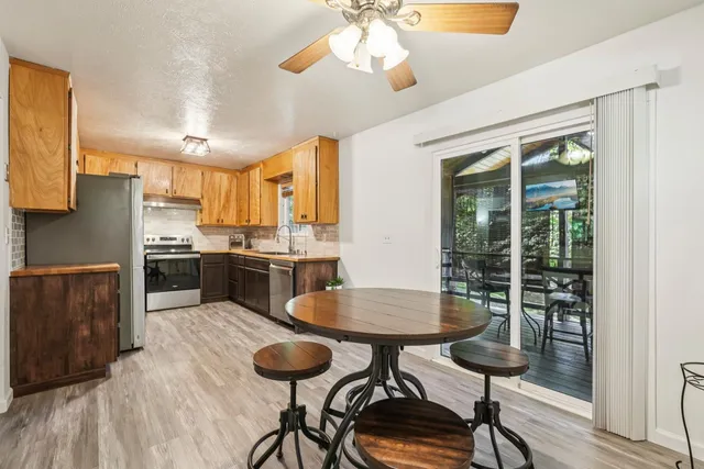a kitchen with stainless steel appliances a dining table chairs and stove