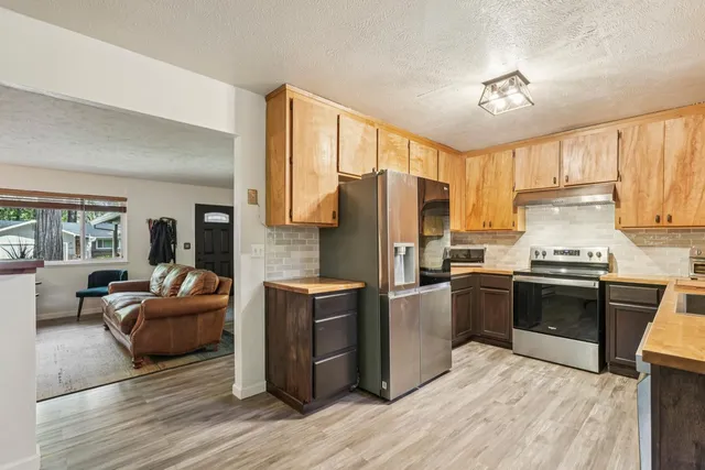 a kitchen with kitchen island granite countertop wooden cabinets and stainless steel appliances