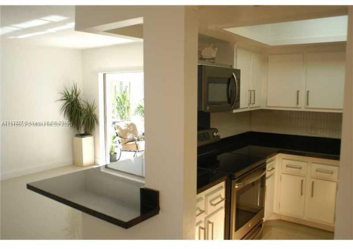 2451 Southwest 82nd Avenue, Unit 106 Davie, FL 33324 - Photo 3 of 10 a kitchen with a sink and a refrigerator