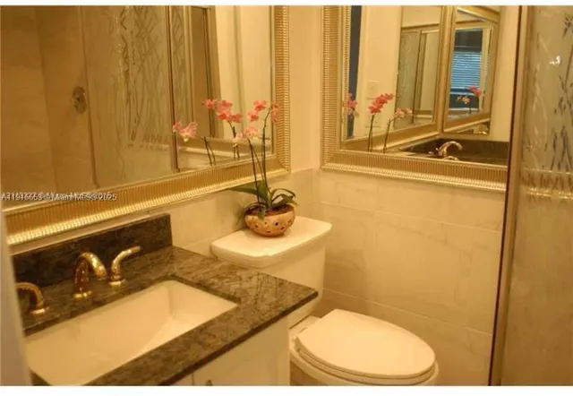 a bathroom with a sink a toilet and a mirror