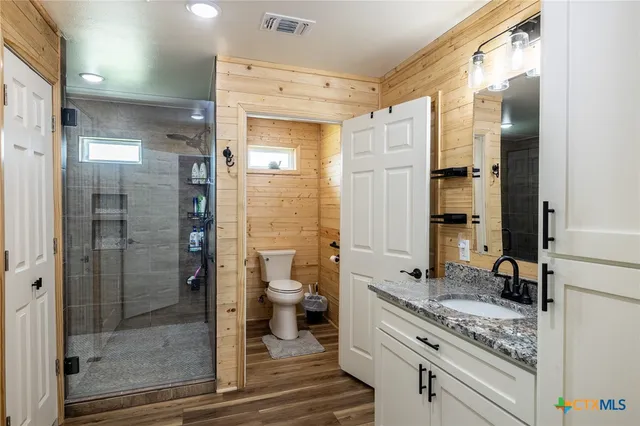 a bathroom with a granite countertop sink toilet and shower