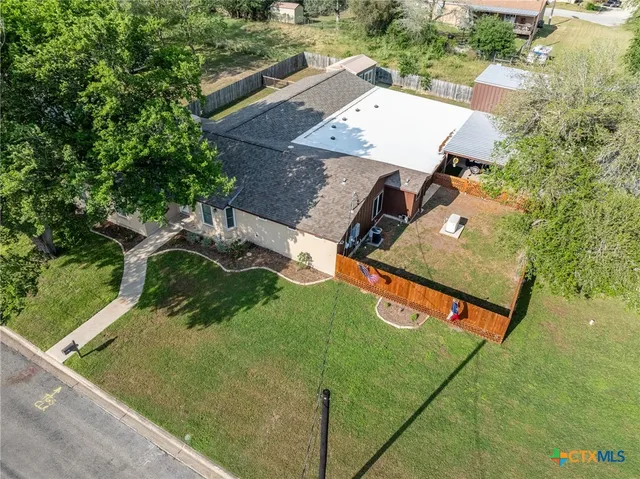 an aerial view of a house with a yard and trees
