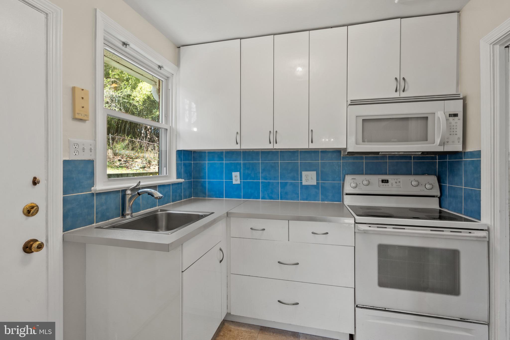 9704 Lorain Avenue Silver Spring, MD 20901 - Photo 10 of 43 a kitchen with granite countertop white cabinets and window
