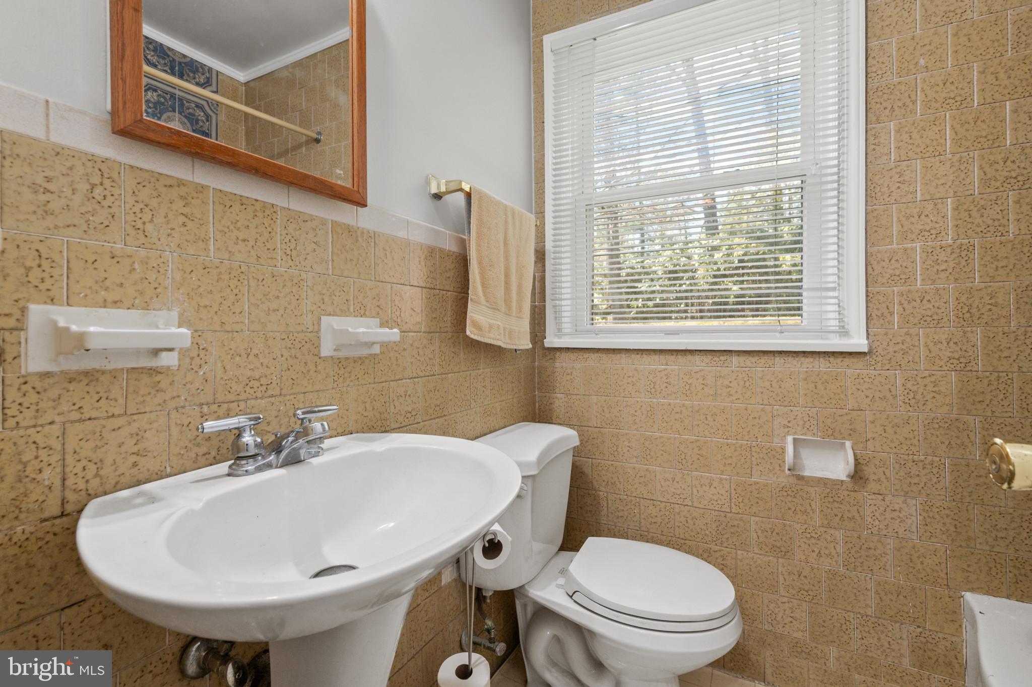 9704 Lorain Avenue Silver Spring, MD 20901 - Photo 15 of 43 a bathroom with a sink a toilet and a mirror