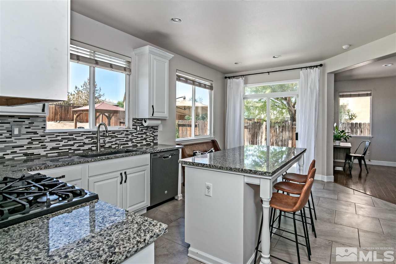 2330 Clementine Lane Reno, NV 89521 - Photo 12 of 32 a kitchen with stainless steel appliances granite countertop a stove a sink and a wooden cabinets