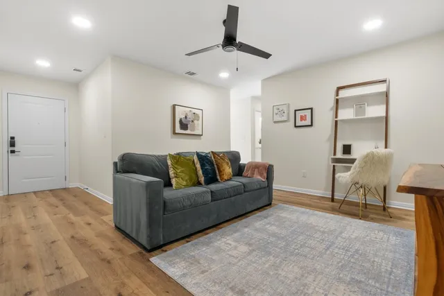 a living room with furniture and a ceiling fan