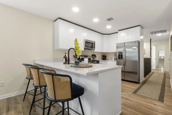 a kitchen with kitchen island a appliances and a refrigerator