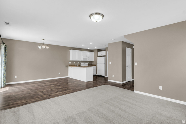 656 South 910 West, Unit 25 Pleasant Grove, UT 84062 - Photo 5 of 25 Open-concept living space featuring light gray walls and a combination of gray carpet and wood-finish flooring.